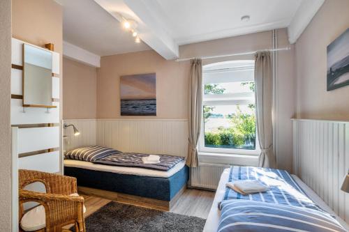 a bedroom with two beds and a window at Ferienhof Harrsen in Pellworm