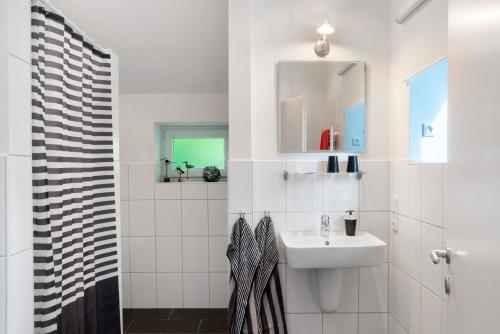 a white bathroom with a sink and a shower at Ferienhaus Neudorf in Varel