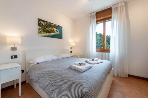 a white bedroom with a bed with towels on it at Villa Bornico Margherita in Toscolano Maderno