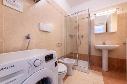 a bathroom with a washing machine and a toilet at Villa Bornico Margherita in Toscolano Maderno