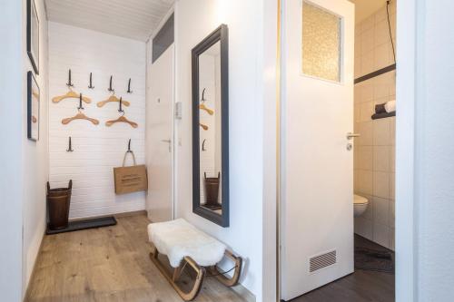 a hallway with a mirror and a stool in a bathroom at Heimelig im Hirschen App 117 in Schönwald