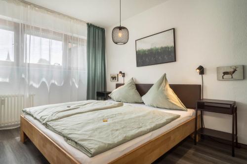 a bedroom with a bed with a large window at Heimelig im Hirschen App 117 in Schönwald