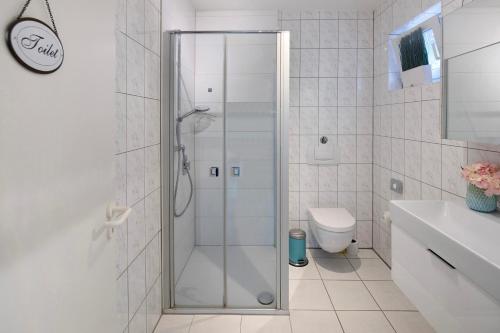 a white bathroom with a shower and a toilet at Ferienwohnung an der Dönche in Kassel