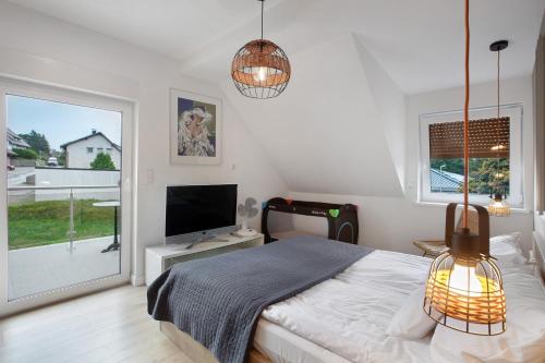 a bedroom with a bed and a flat screen tv at Heimelige Schwarzwaldwohnug Berg in Häusern