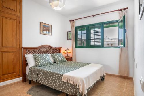 a bedroom with a bed and a window at La Casa de Maika in Guatiza