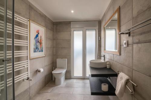 a bathroom with a sink and a toilet and a window at Apartment Abelha in Loulé