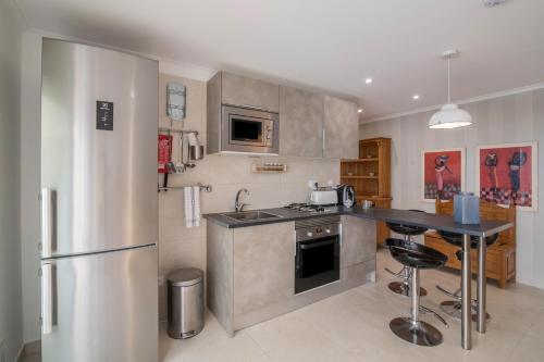 a kitchen with a stainless steel refrigerator and a counter at Apartment Abelha in Loulé
