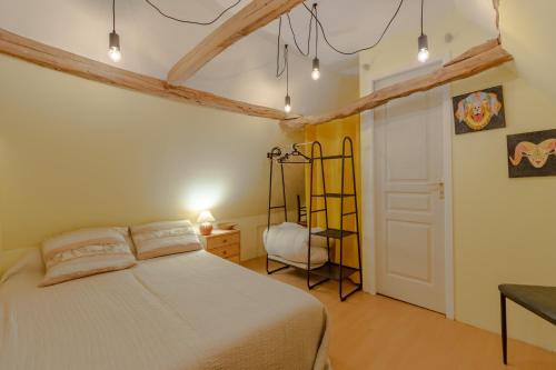 a bedroom with a white bed and a chair at Les Gabernous in Tursac