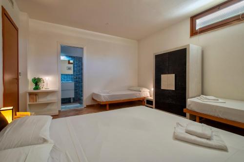 a bedroom with two beds and a window at Villa Olivetta con piscina in Alghero