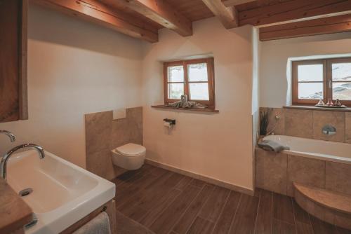 a bathroom with a tub and a toilet and a sink at Ferienhaus Kaiser in Aßling