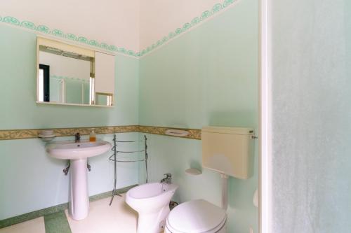 a bathroom with a sink and a toilet and a mirror at Domus mea salento Arazzo Blu in Ugento