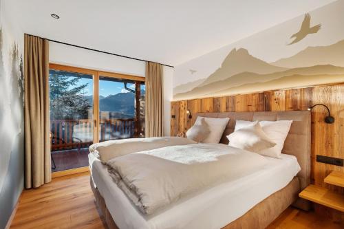 a bedroom with a large bed and a window at Lechnerhof - Clara´s Mountain Lodge in Rodengo