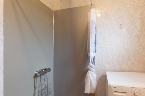 a bathroom with a shower curtain and a toilet at Les Sources Gite Cabernet in Chambonas