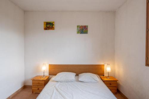 a bedroom with a bed with two night stands and two lamps at Les Sources Gite Cabernet in Chambonas