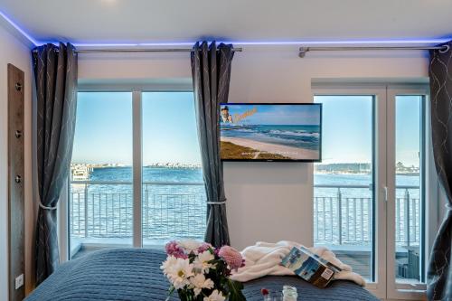 a bedroom with a bed and a flat screen tv at Schleivilla Kapitän James Cook2 in Kappeln