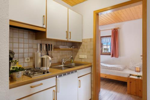 a kitchen with white cabinets and a sink at Oberes Wirtshaus in Titisee-Neustadt