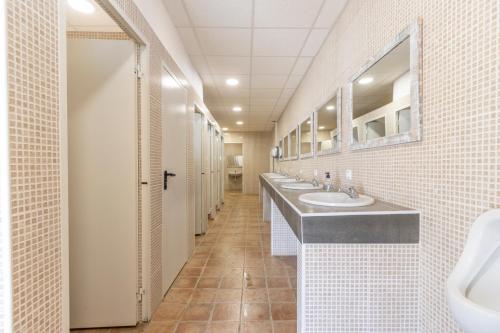 a bathroom with three sinks and two mirrors at Móvil Home Grande in Alós de Balaguer