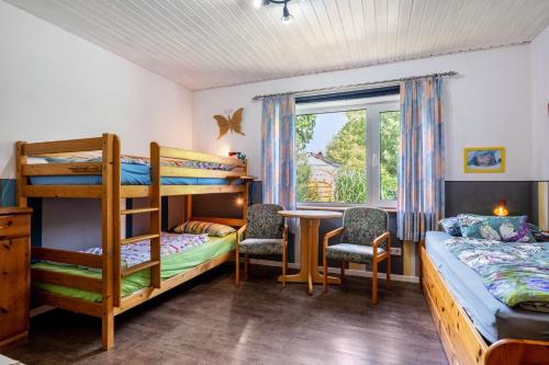 a bedroom with two bunk beds and a table and chairs at Ferienwohnung Caspersen in Viöl