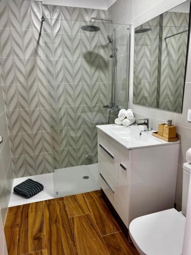 a bathroom with a shower and a white sink at Amber L5 in Armeñime