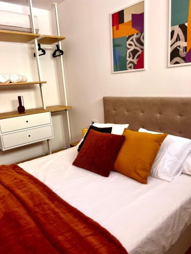 a bed with colorful pillows on it in a bedroom at Amber L5 in Armeñime