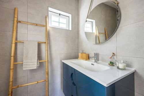 a bathroom with a sink and a mirror at Salema Beach House in Salema