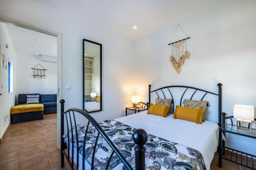 a bedroom with a bed and a mirror at Salema Beach House in Salema