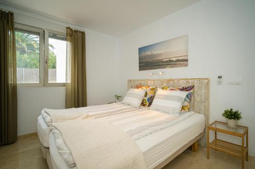 a bedroom with a large bed with white sheets and pillows at Casa Delfin in Moraira