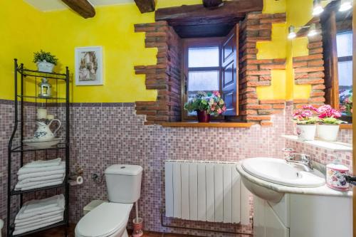 a bathroom with a white toilet and a sink at Apartamento Juntana 1 in Villacarriedo