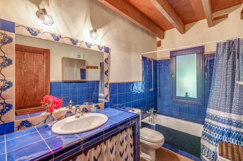 a blue and white bathroom with a sink and a toilet at Can Om in Campos