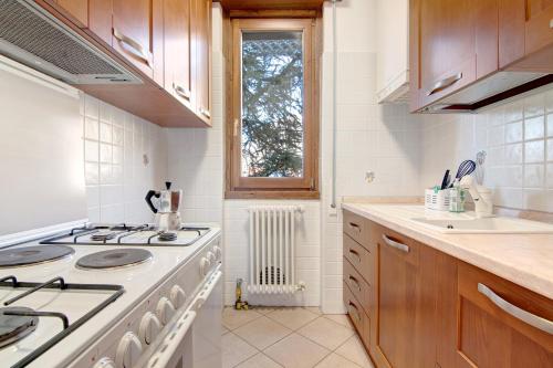 a white kitchen with a stove and a window at Casa Lierna in Lierna