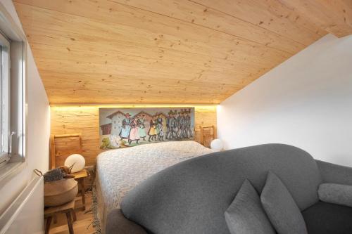 a bedroom with a bed and a couch at Haus Alpenveilchen - Appartement 4 in Schönau am Königssee