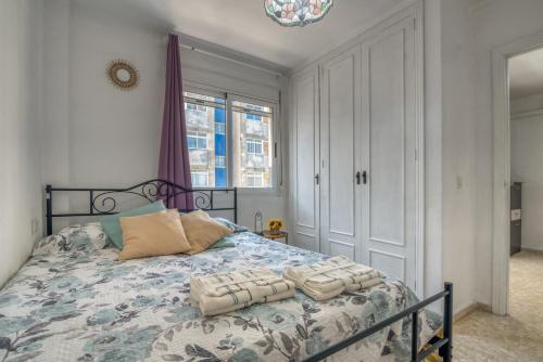 a bedroom with a bed with a blue comforter at Apartamento en playa de Daimús in Daimuz