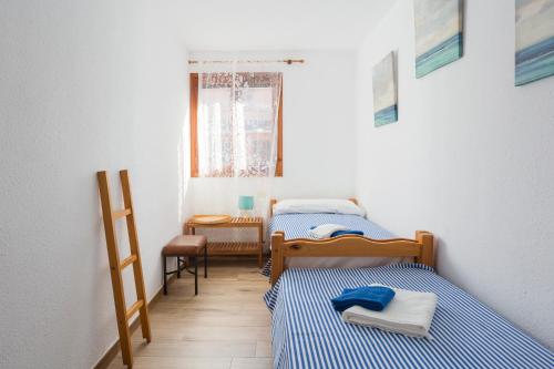 two beds in a small room with a window at Adosado Mareny Blau in Mareny Blau