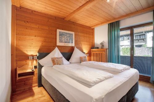 a bedroom with a large bed in a room with wooden walls at Ferienwohnung Schliersee in Schliersee