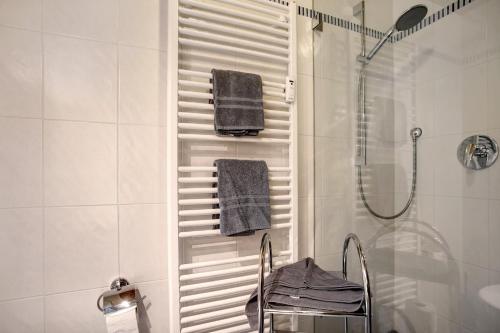 a bathroom with a shower and a towel rack at Ferienwohnung Schliersee in Schliersee
