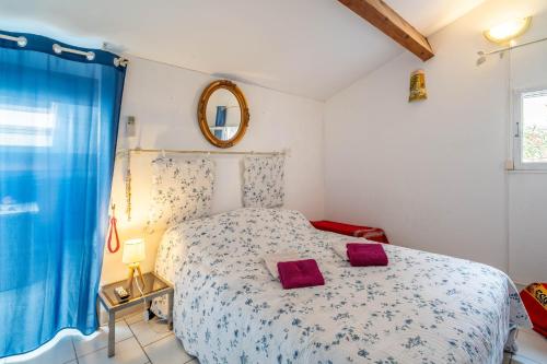 a bedroom with a bed with two red pillows on it at Maison 38m2 proche de la mer in Gruissan