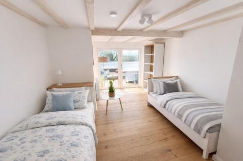a bedroom with two beds and a window at Ferienhaus 'Huus ant Diek mit Pool' in Norden