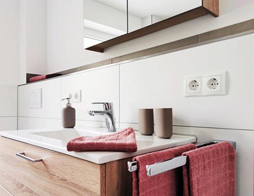 a bathroom with a sink and red towels at Rehkitz in Baiersbronn