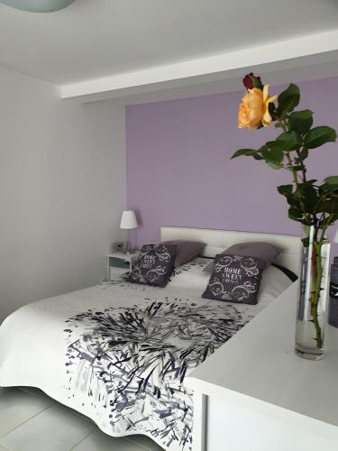 a bed with black and white sheets and a vase with a flower at Chambre Chanteloup in Mont-Dol