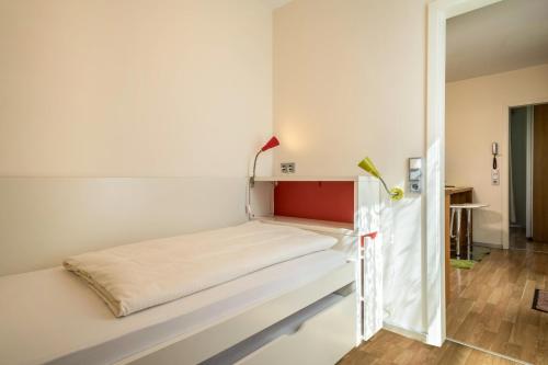 a bed in a room with white walls at Ferienhaus Falkenhalde in Deggenhausertal