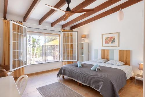 a bedroom with a bed and a large window at Casa Can Mussenya in Illes Balears