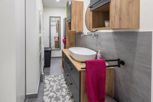 a bathroom with a white sink and a pink towel at Traumwohnung Radolfzell am Bodensee in Radolfzell am Bodensee