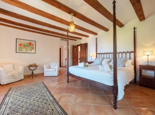a bedroom with a four poster bed and a living room at Sa Cala in Deia