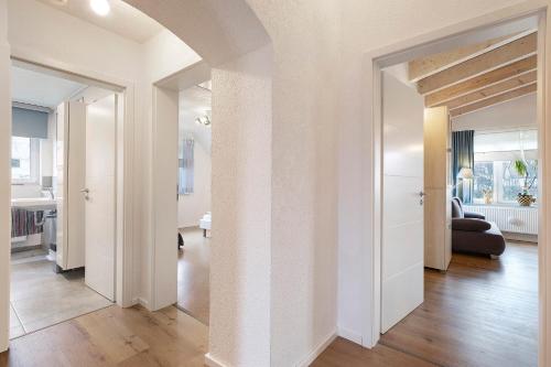 ein offener Flur mit weißen Wänden und ein Wohnzimmer in der Unterkunft Rosensteinferien in Heubach