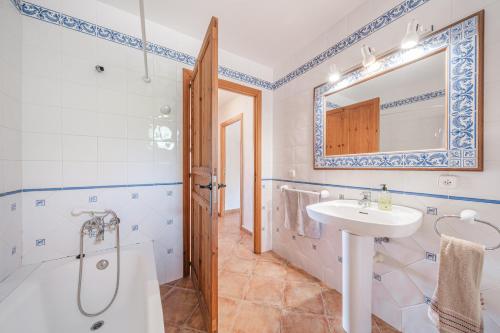 ein Badezimmer mit Badewanne, Waschbecken und Spiegel in der Unterkunft Son Maimo in Petra