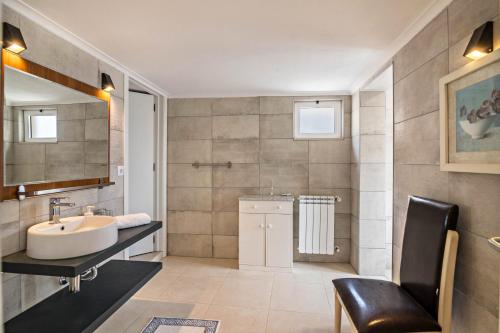 a bathroom with a sink and a chair in it at Apartment Mel de Flor in Loulé