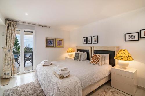 a bedroom with a bed and a large window at Apartment Mel de Flor in Loulé