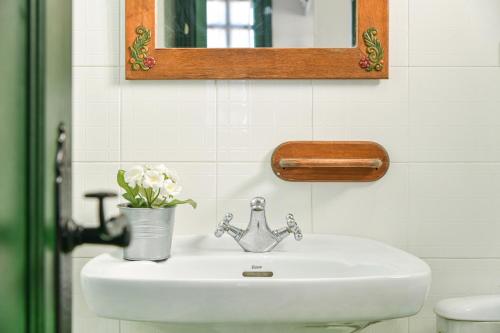 a bathroom sink with a mirror and a vase of flowers at Mimosa B1 in Puerto del Carmen