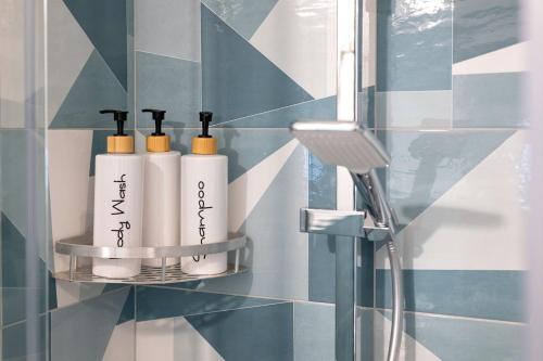 a bathroom with three bottles ofodorizers on a shelf at Suite Le Cementine in Mottola