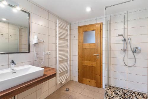 a bathroom with a sink and a shower and a mirror at Urlaub Im Kulturdenkmal in Alpirsbach